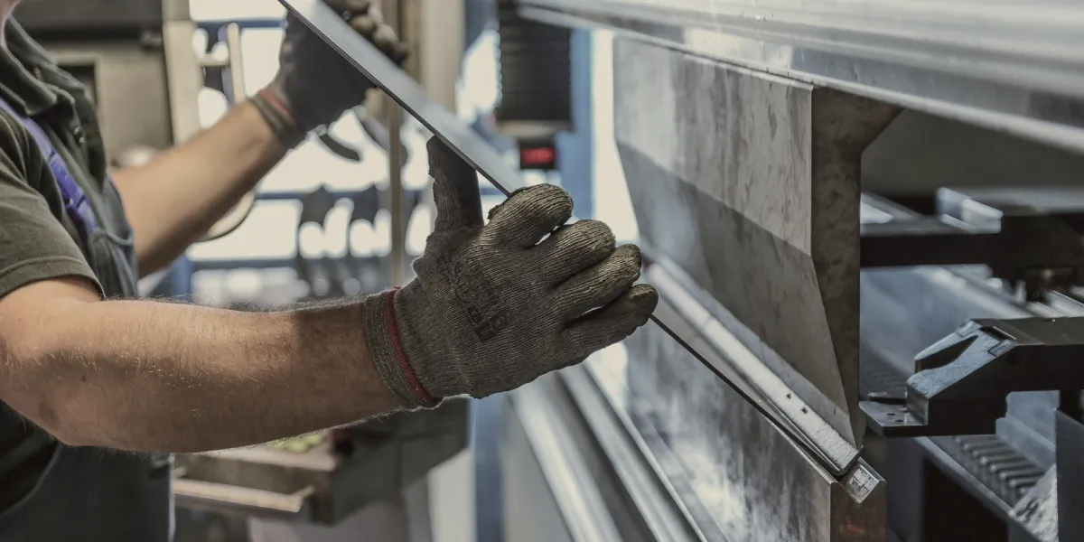 Worker bending metal using a machine