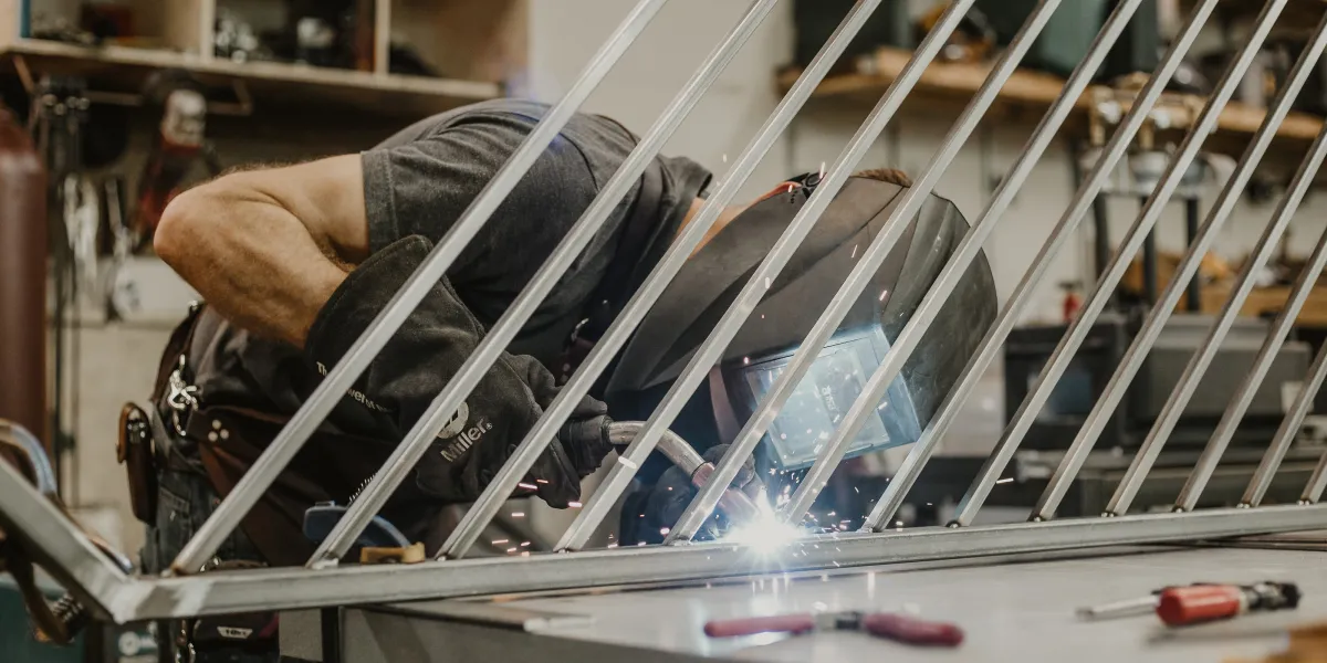Welder leaning into work on angled metal project