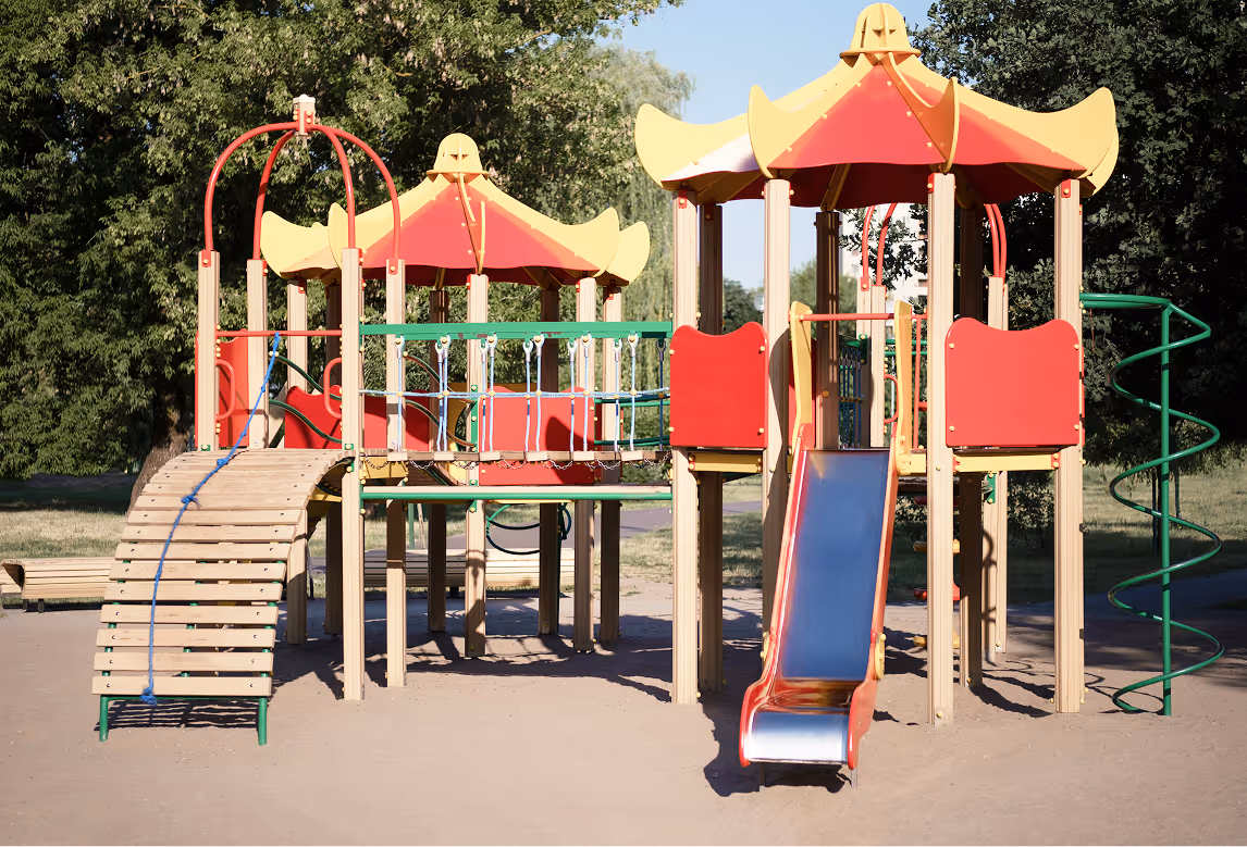Bunter Spielplatz mit Rutschen und Klettergeräten