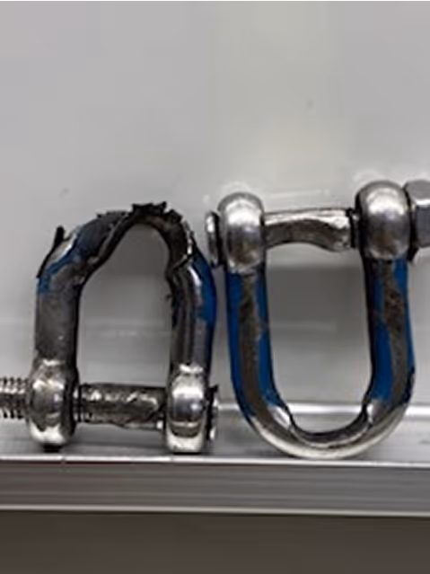 Zwei Metallbügel, einer davon beschädigt mit gequetschtem und gerissenem Bezug, der andere intakt.