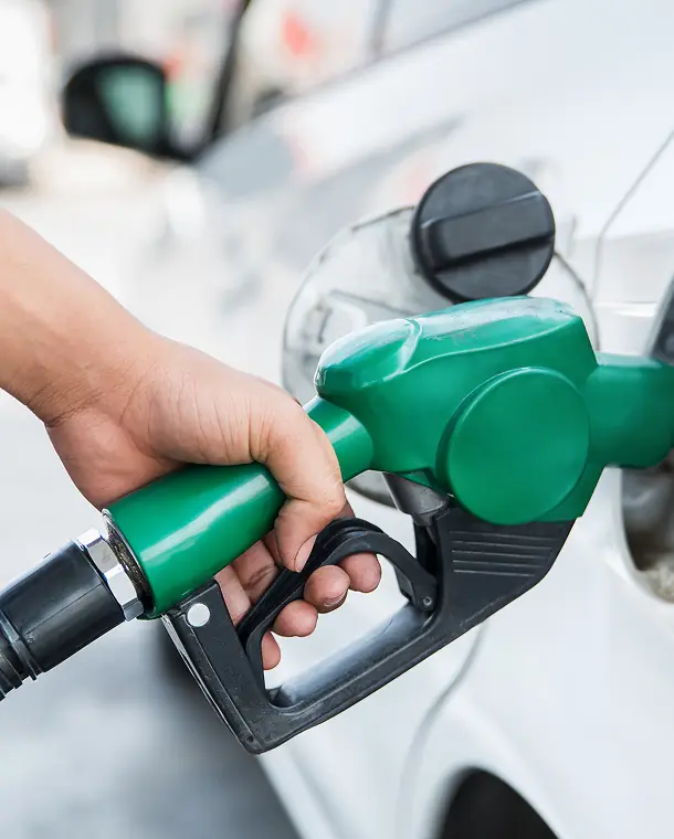 Hand grips a green gas pump nozzle.
