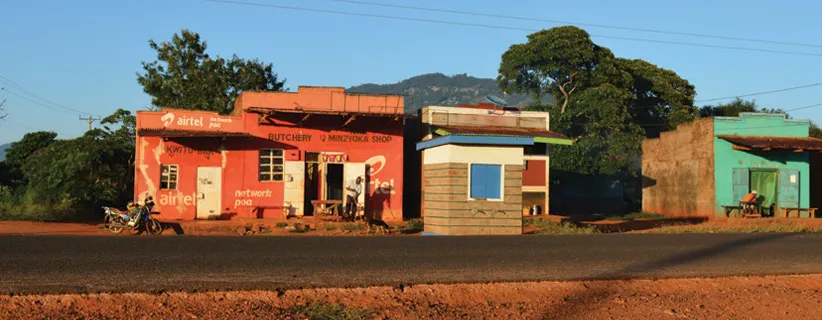Colorful Airtel storefronts along dusty road.