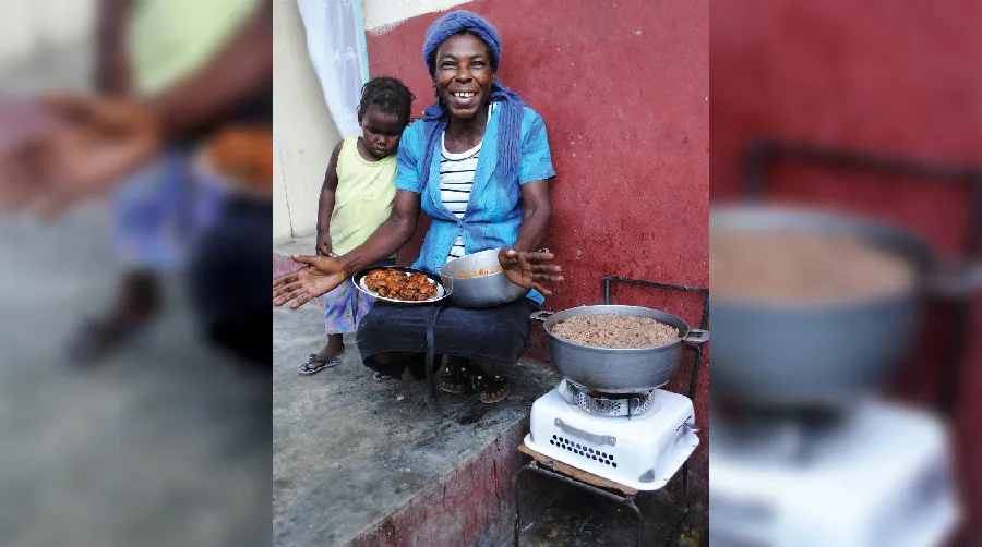 Smiling woman cooks outdoors with child