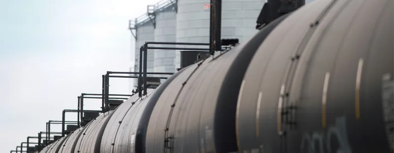 Row of black oil tank cars on tracks
