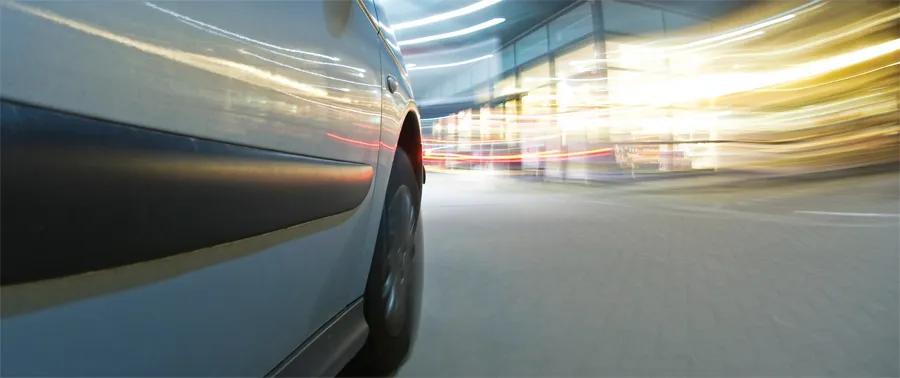 Side view of speeding car on blurred city street