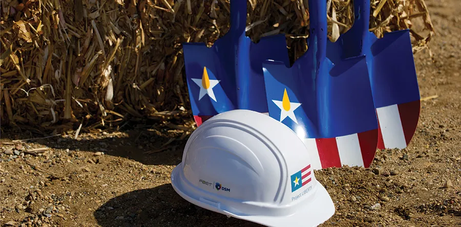 A white hard hat and shovels on the ground
