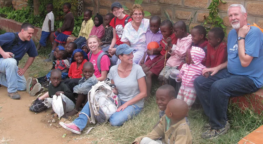 Emily Anderson, Connie Hancock, Tim Gibson, Beau Schmaltz, Kayla Schlechter and Debbie Anderson make friends with the Sultan Hamud children outside their hotel.