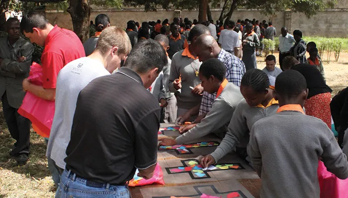 Steve Lewis and Dan Machata help the girls make stained glass cross crafts.