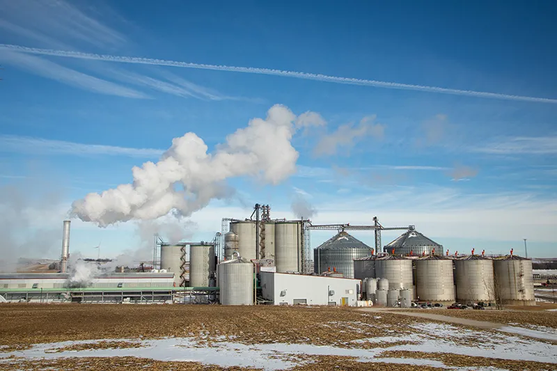 Grain silo complex with smokestacks.
