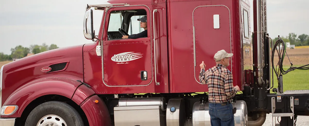 Red semi-truck with driver inside cab