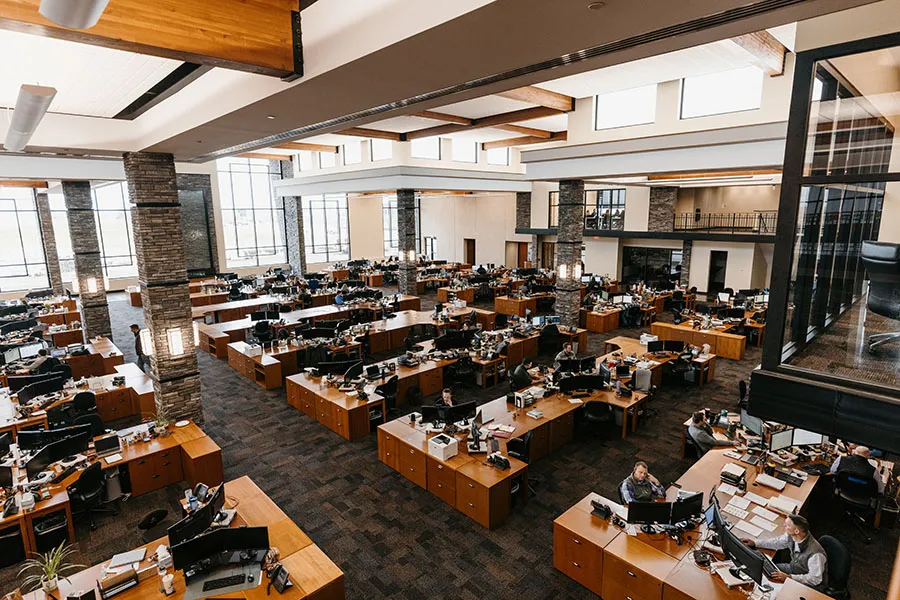 Open-plan trading floor with rows of desks.