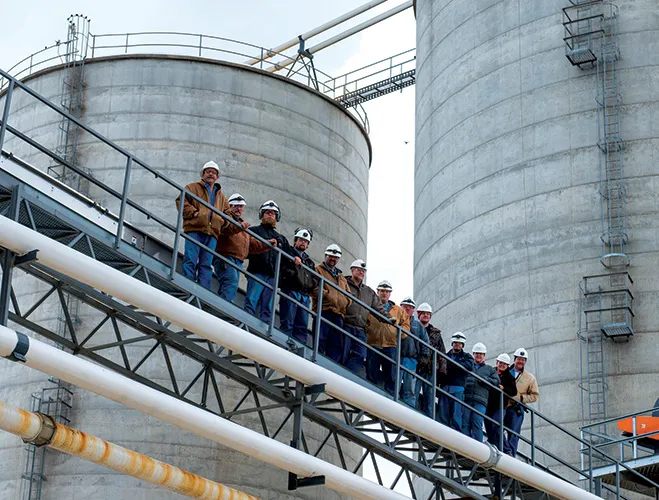 Group of workers in hard hats on steel walkway