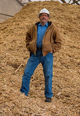 Dean Frederickson, General Manager at POET Biorefining – Chancellor stands in front of wood chips to be fed into the solid waste fuel boiler.