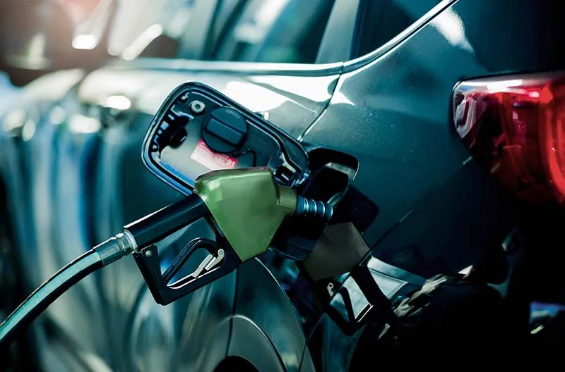 Green gas nozzle fueling a blue car