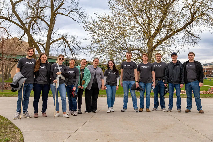 Group of people in POET shirts posing outdoors.