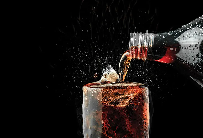 Cola poured into a glass with ice.