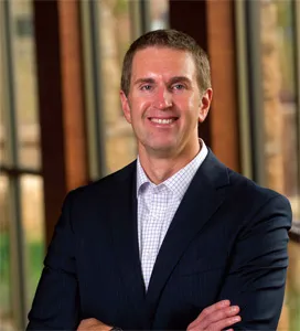 Lowell Broin in suit with arms crossed.