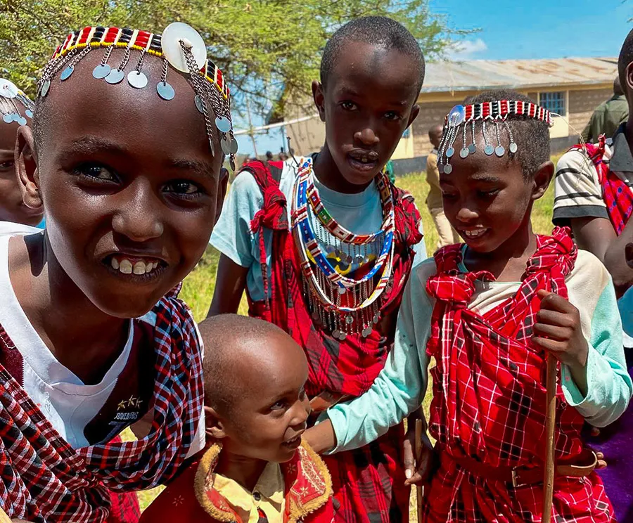 Smiling child in foreground with beaded headpiece.