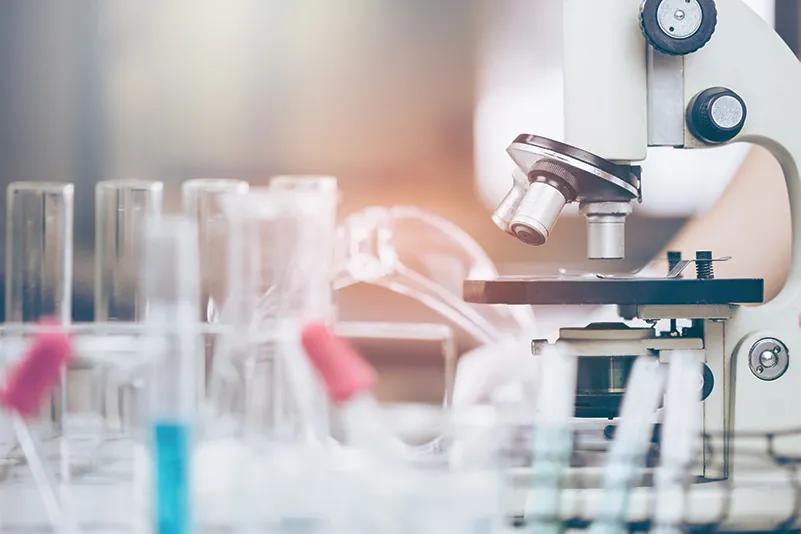 Microscope on a lab bench with glassware