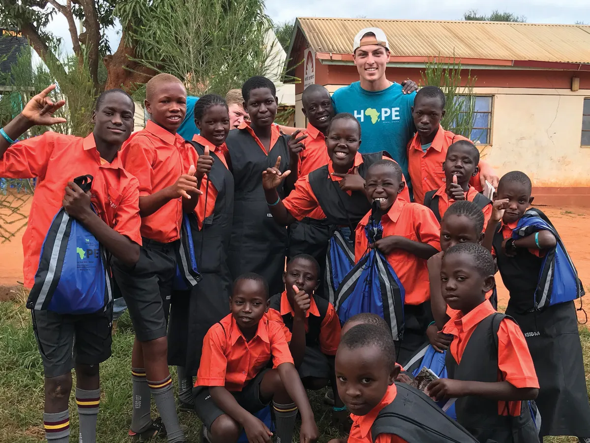A group of students with a teacher smiling at the camera 