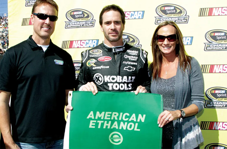 Racing driver posing with American Ethanol sign.