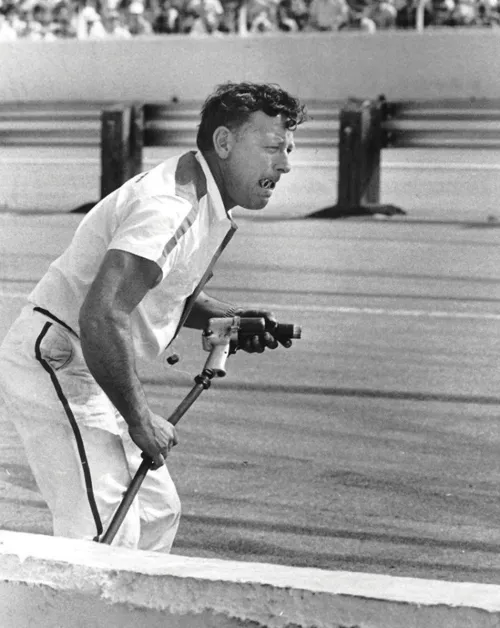 Herb Nab waits to change tires with lug nuts in mouth circa 1960s.