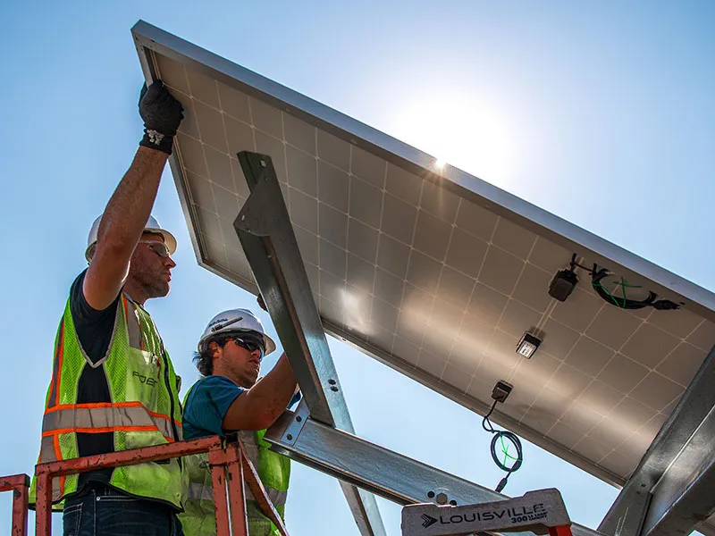 POET engineers install a solar panel.