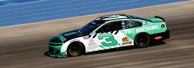 Green race car with bioethanol livery on track.
