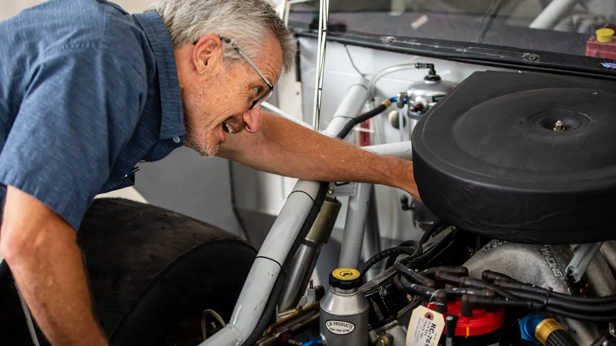 Dr. Randolph looking at car engine