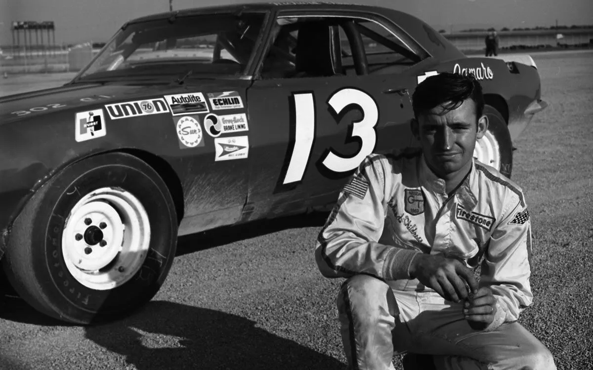 Richard kneeling beside number 13 car.