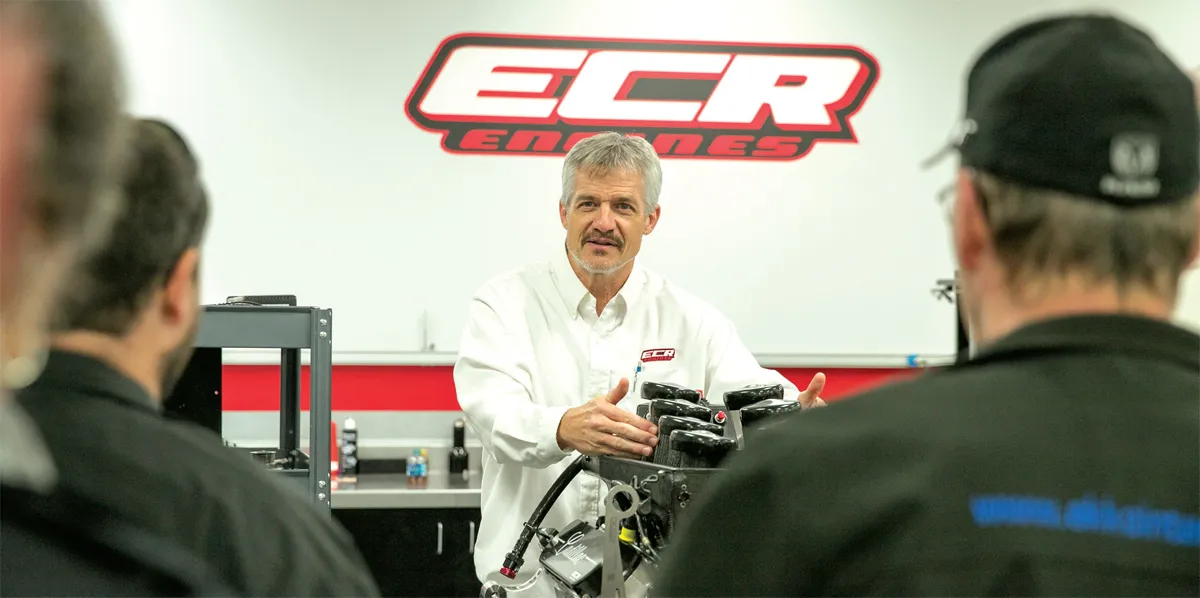 Andy in white shirt explains engine parts.