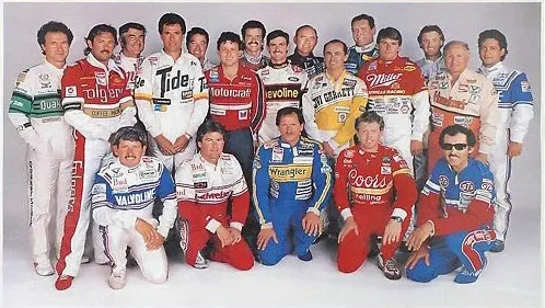 Group of race car drivers in racing suits.