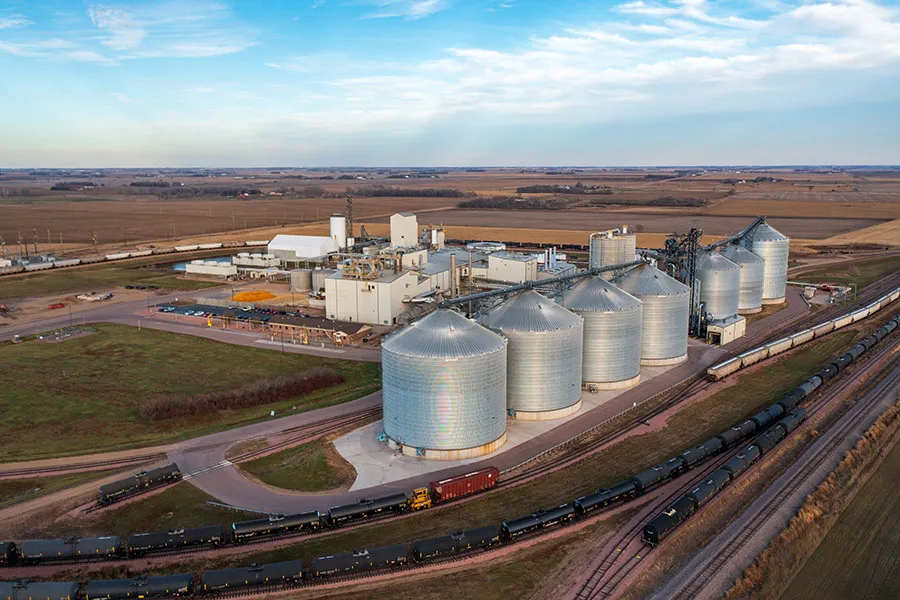 Row of grain silos beside a rail yard.