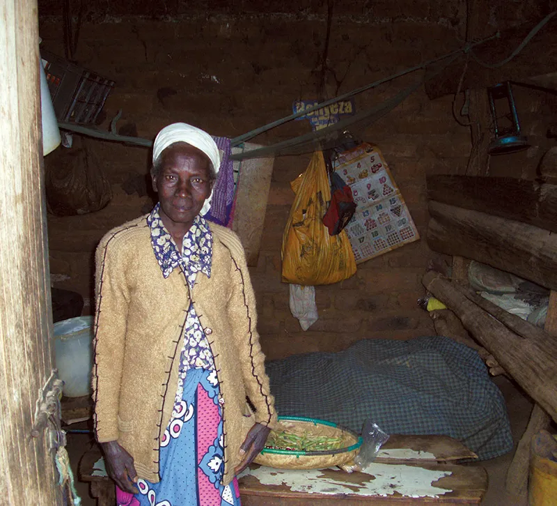 A woman standing in a rustic hut.