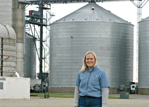 Audrey  standing outside in front of huge tanks 