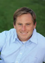 Marcus headshot sitting on the grass and smiling at the camera