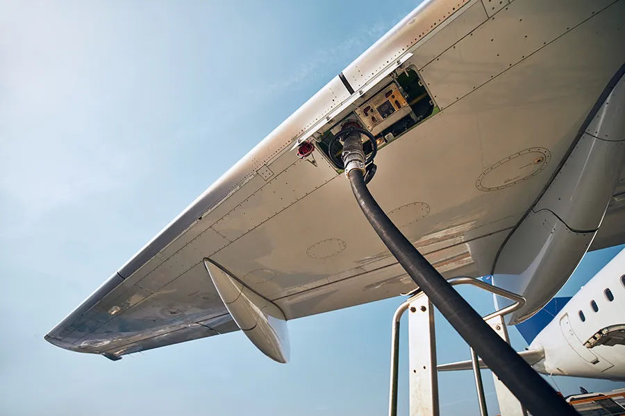 Fueling hose attached to aircraft wing.