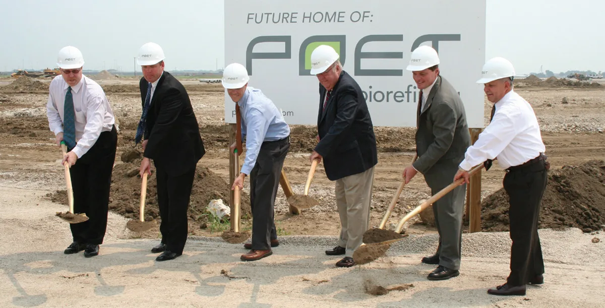 A group of men holding shovels and smiling