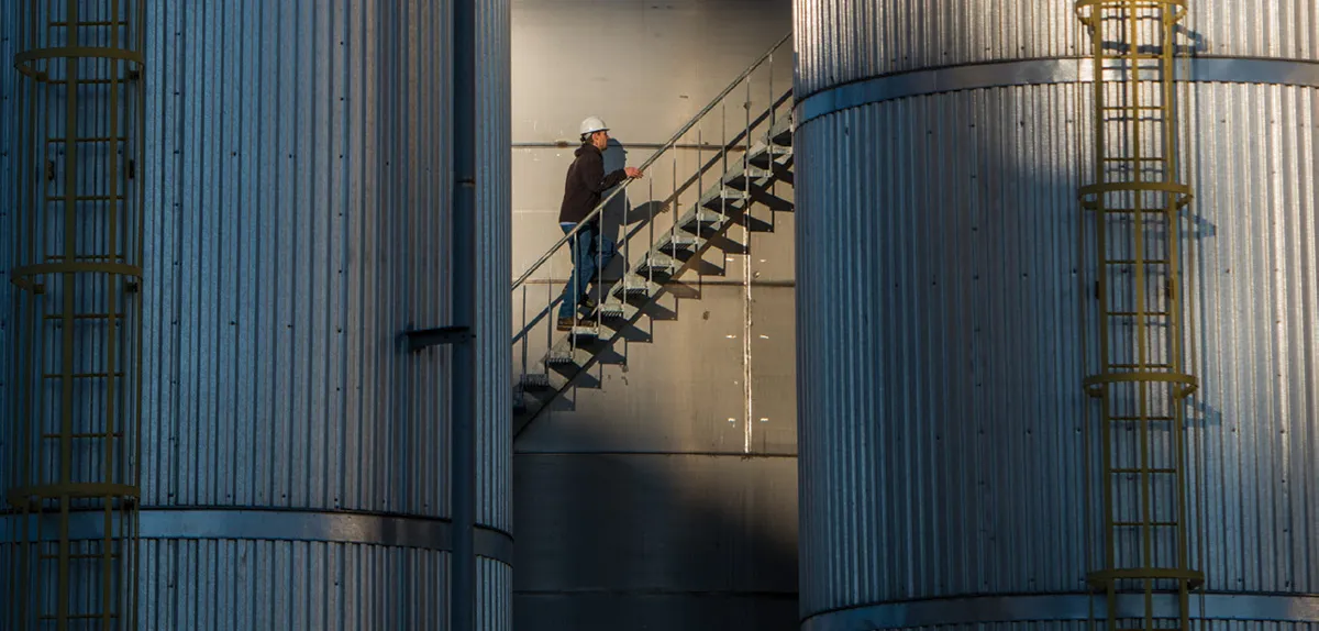 A man going up stairs of a huge tank