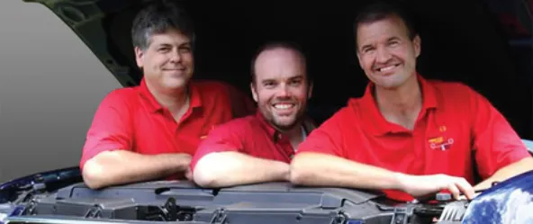 Three men in red T-shirt smiling at the camera