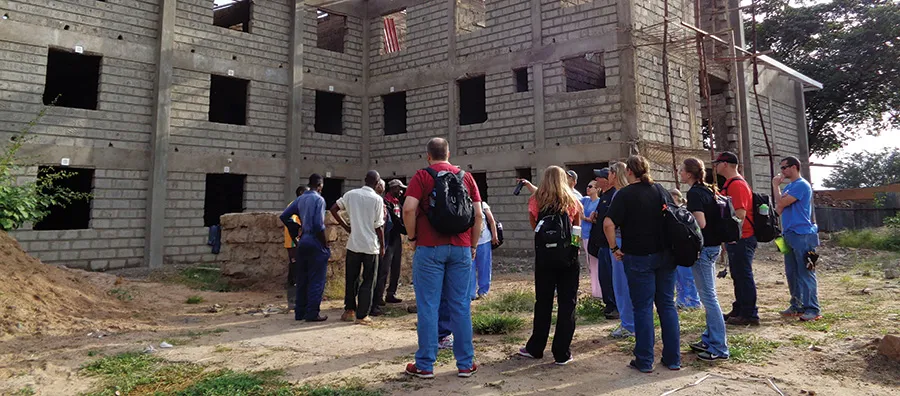 A group of people viewing a building under construction.