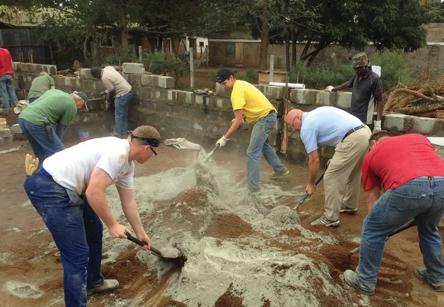 Trevor Peter, Dennis Ausborn and Scott Radigan mix cement.