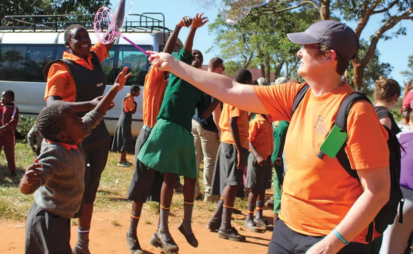 Lisa Hilder, Mission Hope Trip Leader, plays with students.