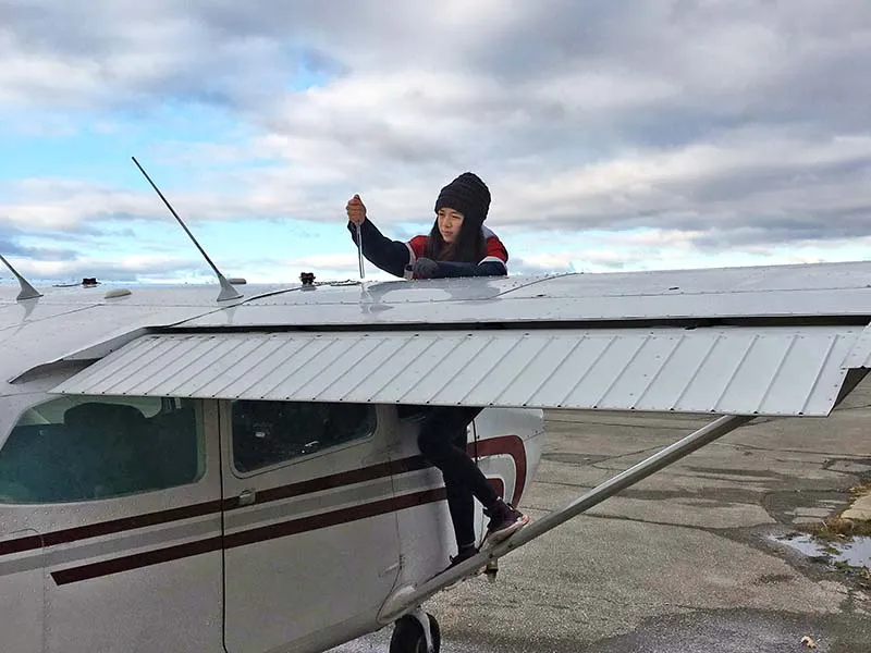Woman on the wing of a small airplane