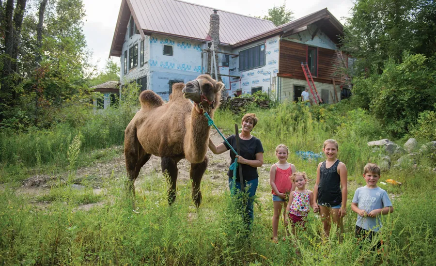 Colleen holding the camel’s rope, taking a picture with four children