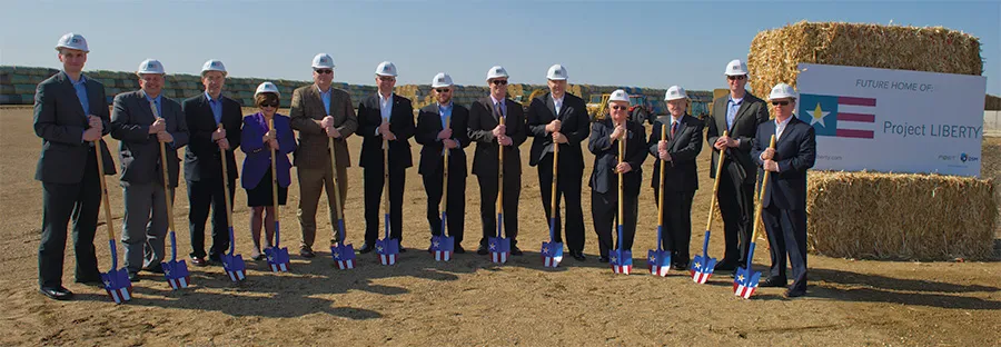 A group of people wearing hard hats and holding shovels