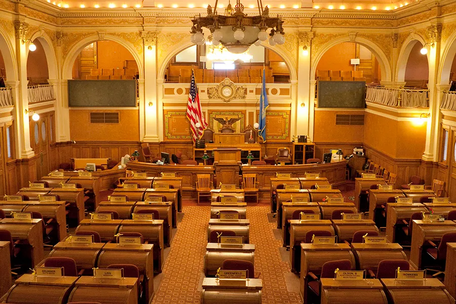 Legislative chamber with desks and flags