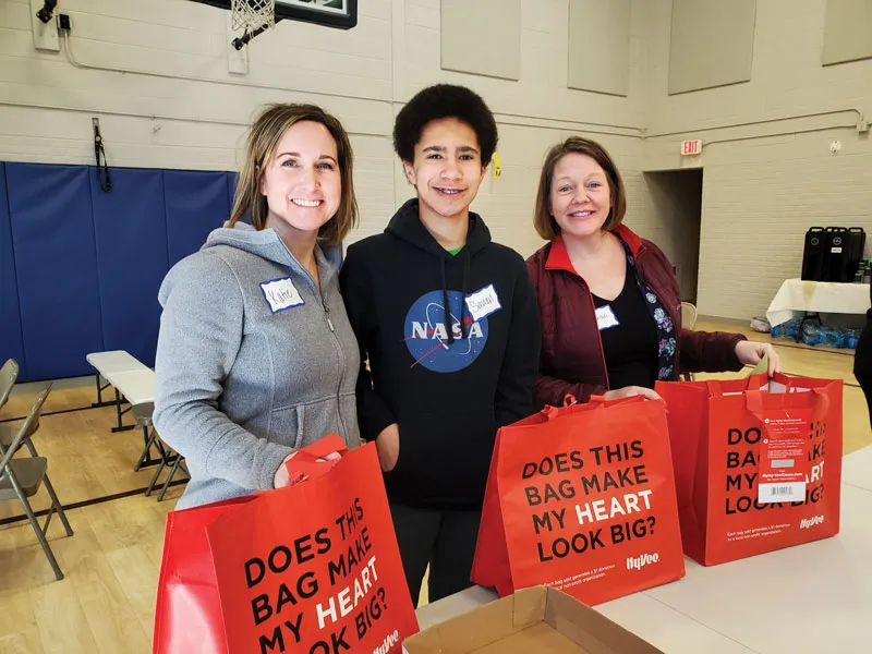 POET team members and their families package donations for Women’s Day of Service
