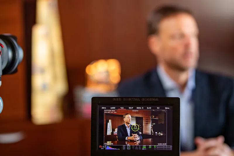 Steve in suit being interviewed on camera