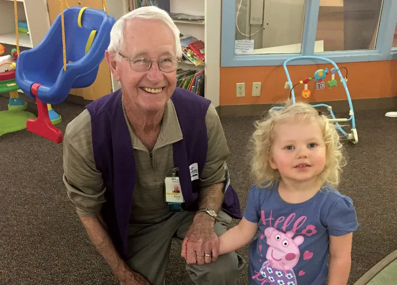 Tatum in the playroom with a volunteer named Fred